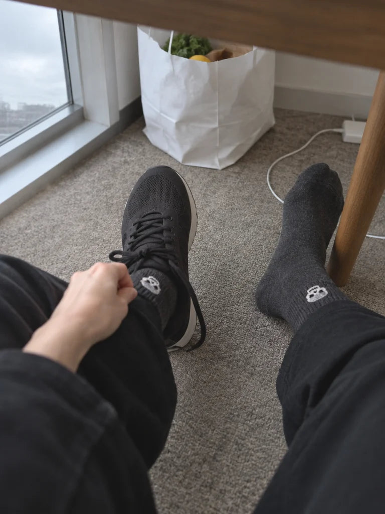 A customer's own photo taken downward beneath a home desk: the charcoal mid-calf Halloween socks fro