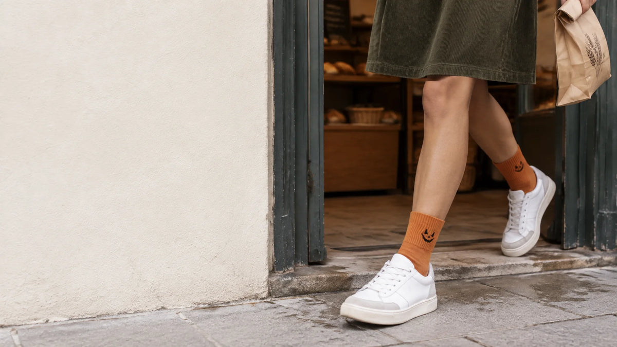 A fashion campaign photograph of the exact mid-calf Halloween socks in reference r06, with charcoal