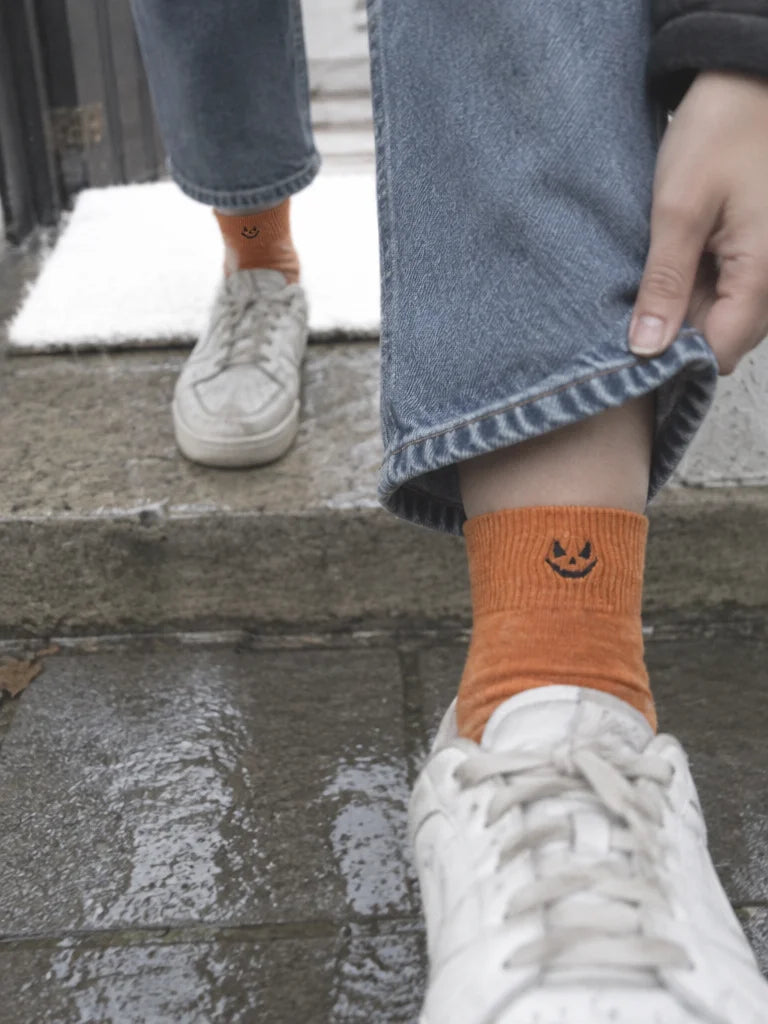A customer's own photo, taken downward at her feet while leaving home: the orange mid-calf Halloween